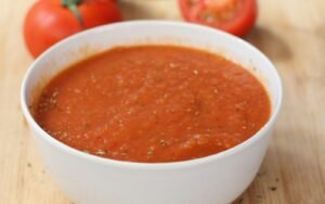 Kom geroosterde tomatensoep met verse basilicum