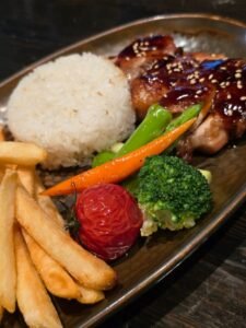 Kip teriyaki met rijst en groenten op een bord