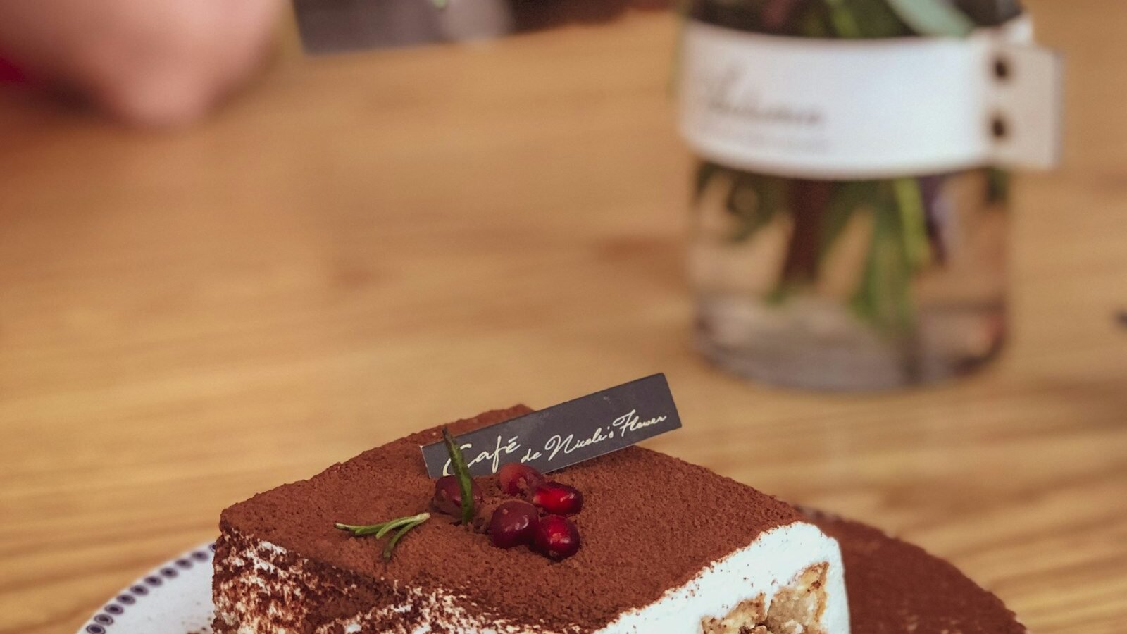 Portie tiramisu bestrooid met cacaopoeder, laagjes mascarponecrème en in koffie gedrenkte lange vingers zichtbaar