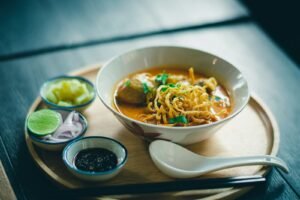 Kom tom kha gai, romige Thaise kokossoep met kip, champignons, citroengras en verse koriander