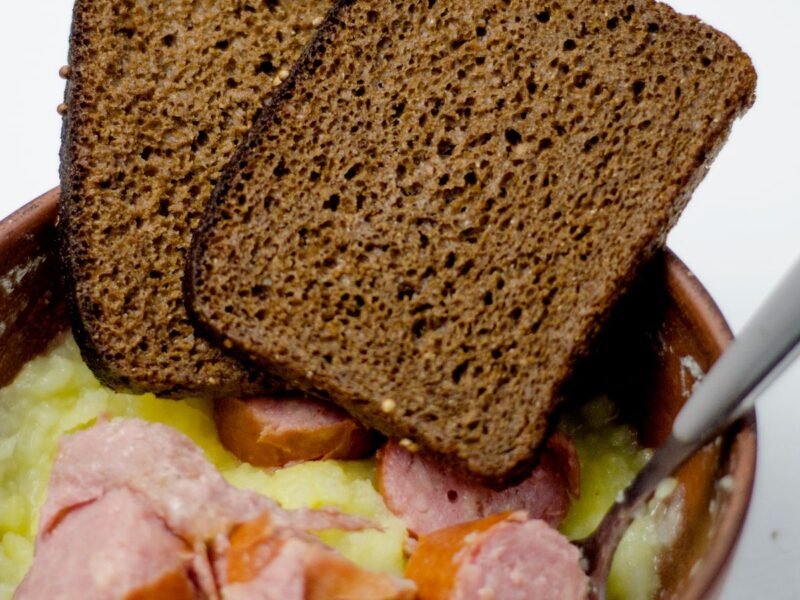 Kom stamppot met plakjes rookworst en roggebrood