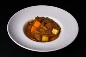 Bord met stoofvlees in een donkere, glanzende saus