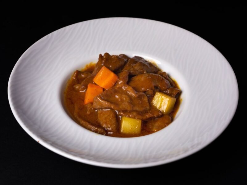 Bord met stoofvlees in een donkere, glanzende saus