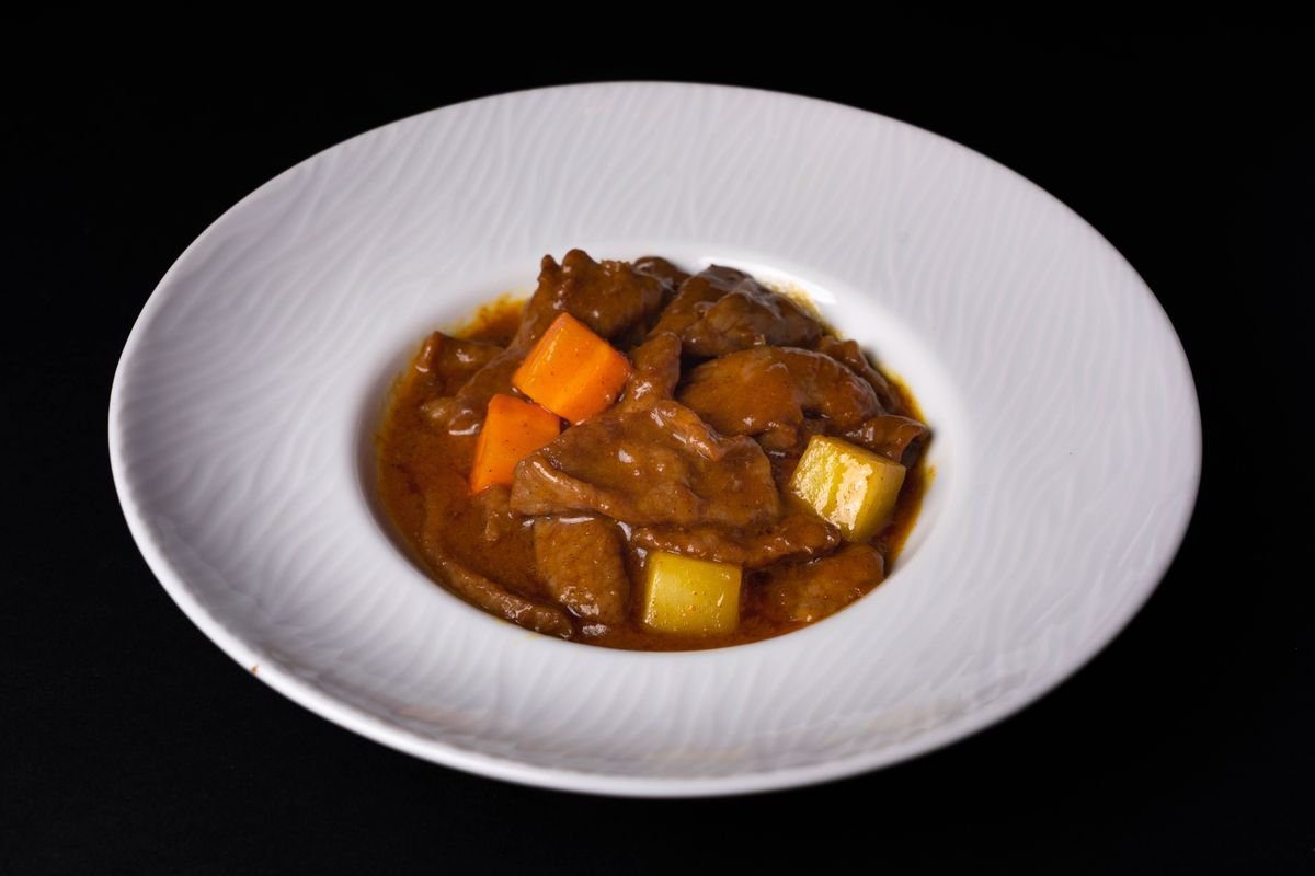 Bord met stoofvlees in een donkere, glanzende saus